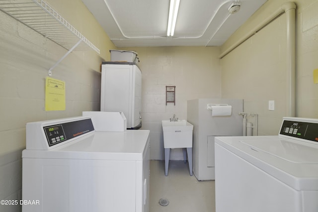 shared laundry area with washing machine and dryer and concrete block wall