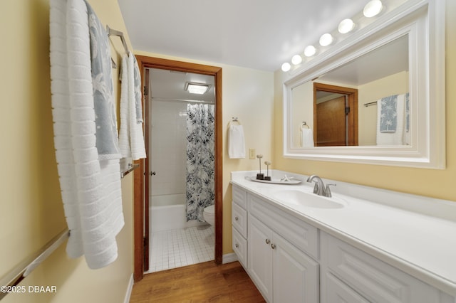 full bathroom with toilet, shower / bath combo, wood finished floors, and vanity