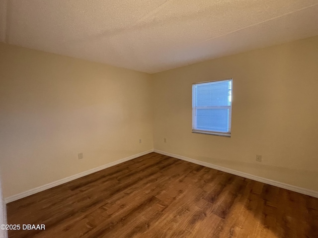 empty room featuring a textured ceiling and wood-type flooring