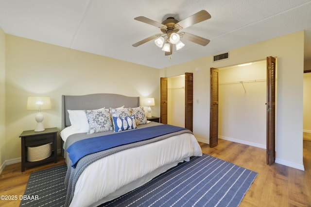 bedroom with visible vents, baseboards, and wood finished floors