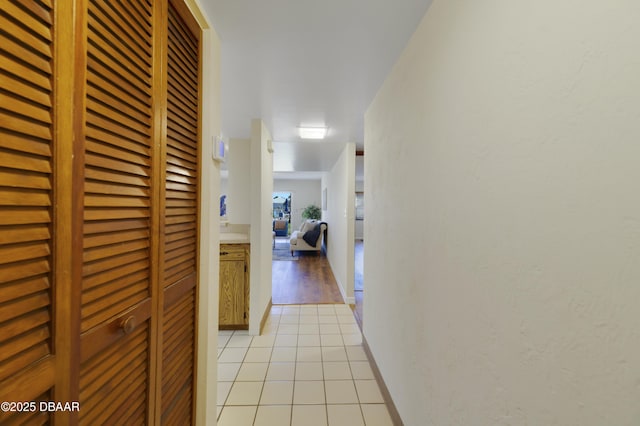 hallway with baseboards and light tile patterned flooring