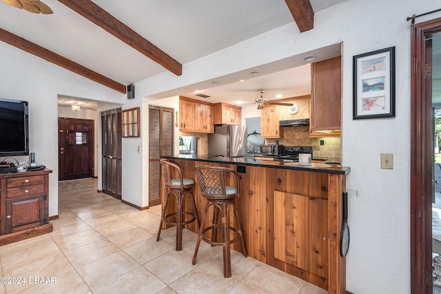 kitchen featuring kitchen peninsula, tasteful backsplash, vaulted ceiling with beams, stainless steel refrigerator, and a breakfast bar area