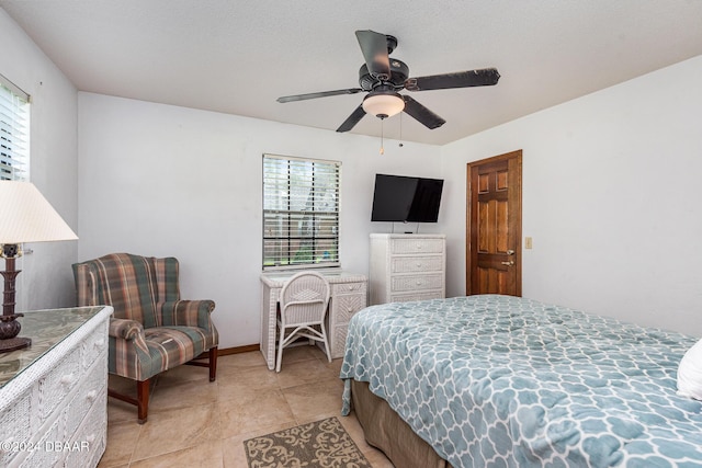 bedroom featuring multiple windows, ceiling fan, and light tile patterned flooring