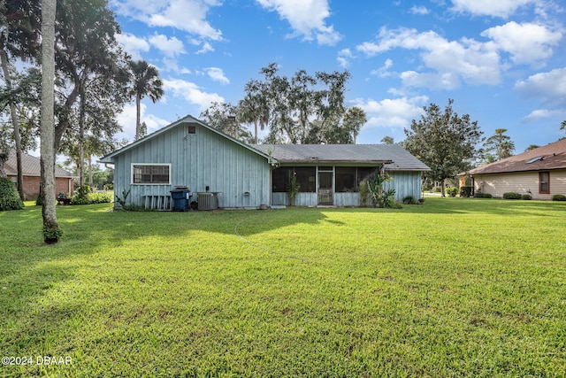 view of front of property featuring a sunroom, a front lawn, and central AC unit