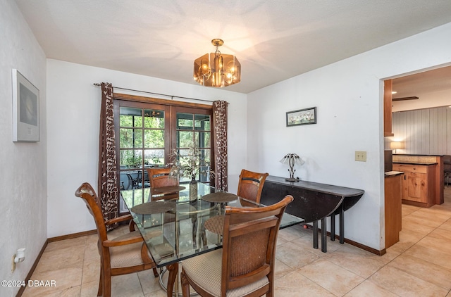 tiled dining room with a chandelier