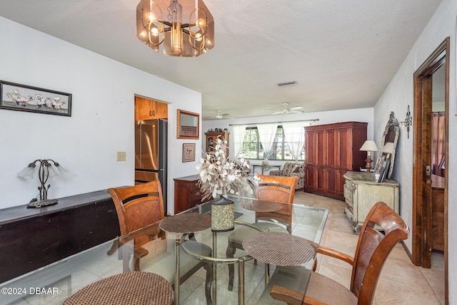 dining area with a textured ceiling, ceiling fan with notable chandelier, and light tile patterned flooring