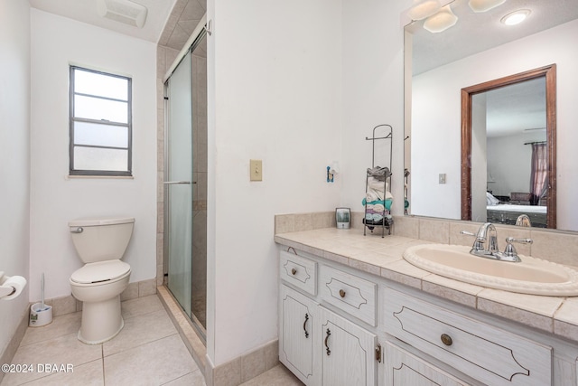 bathroom featuring tile patterned floors, vanity, walk in shower, and toilet