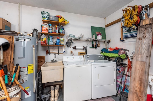 laundry area featuring washing machine and dryer, electric water heater, and sink