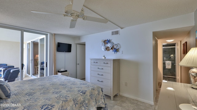 bedroom with light tile patterned flooring, ceiling fan, and a textured ceiling