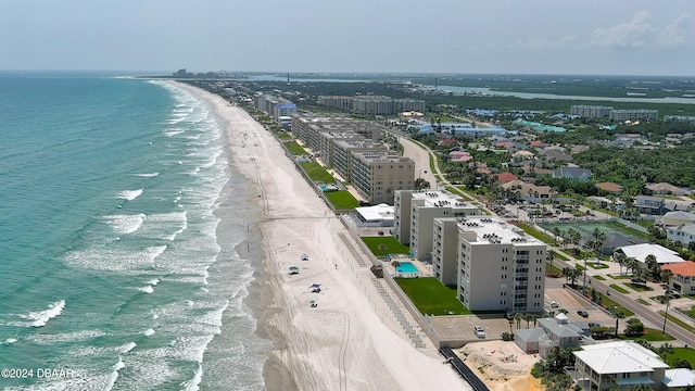 birds eye view of property featuring a water view and a beach view