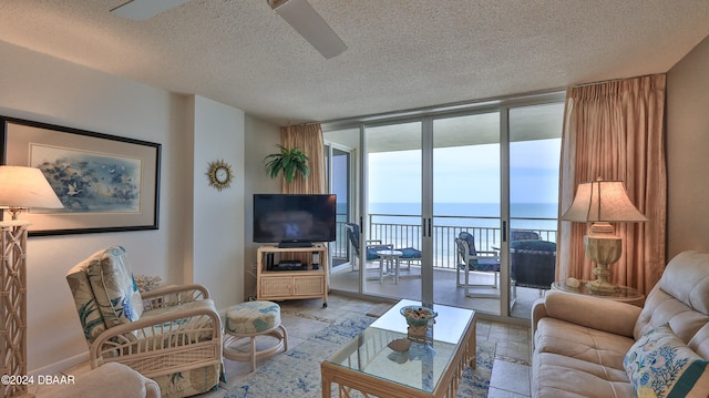 living room featuring a textured ceiling, a wall of windows, and ceiling fan