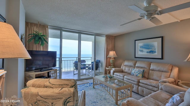 living room with a textured ceiling, hardwood / wood-style floors, ceiling fan, and floor to ceiling windows