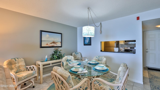 tiled dining area with a textured ceiling