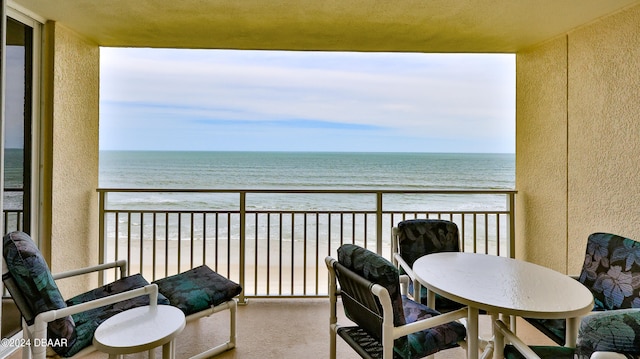 balcony featuring a beach view and a water view