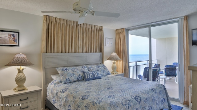 bedroom featuring expansive windows, access to outside, a textured ceiling, and ceiling fan