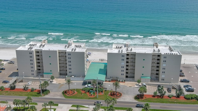 drone / aerial view featuring a water view and a beach view