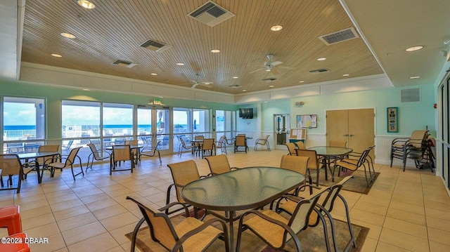 tiled dining area featuring a water view, ceiling fan, and wooden ceiling