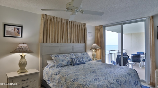 bedroom featuring a water view, a textured ceiling, ceiling fan, and access to exterior