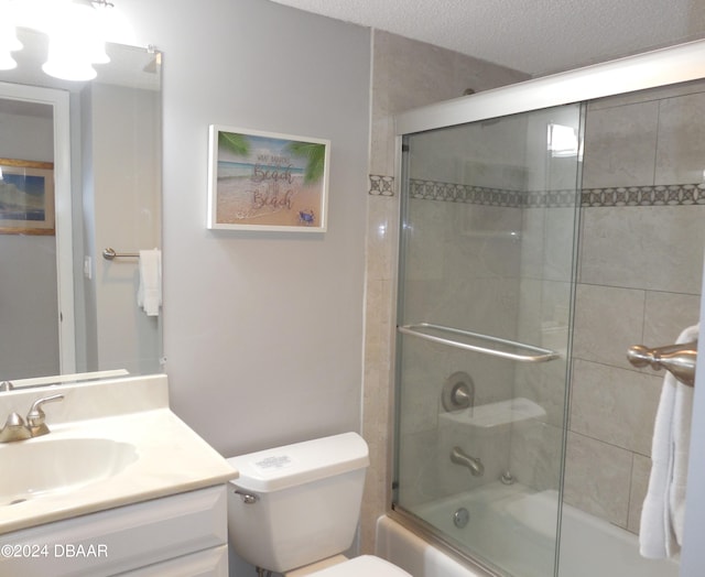 full bathroom featuring toilet, vanity, a textured ceiling, and enclosed tub / shower combo