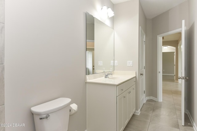 bathroom with tile patterned flooring, vanity, and toilet