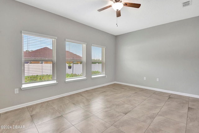 tiled spare room with ceiling fan and a healthy amount of sunlight