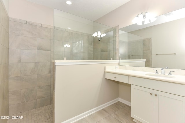 bathroom with tiled shower, vanity, and tile patterned floors