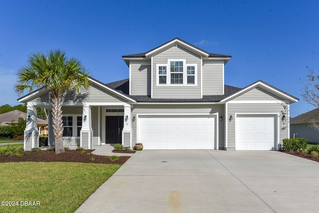 view of front facade featuring a porch, a front yard, and a garage