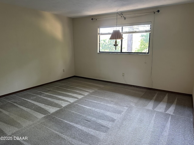 empty room with baseboards and carpet