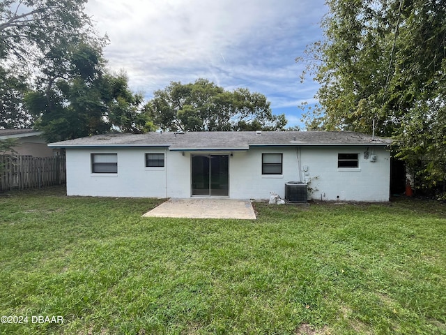 rear view of property with central air condition unit, a yard, and a patio area