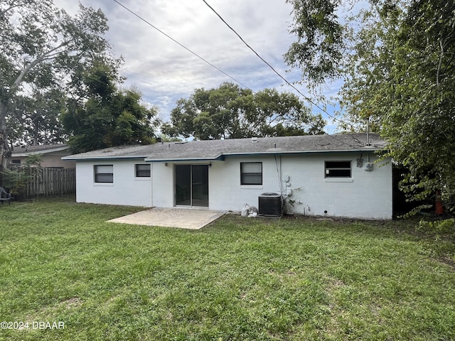 506 Cambridge Cir S, Daytona, FL 32119 - back of property featuring concrete block siding, a patio area, and roof with shingles