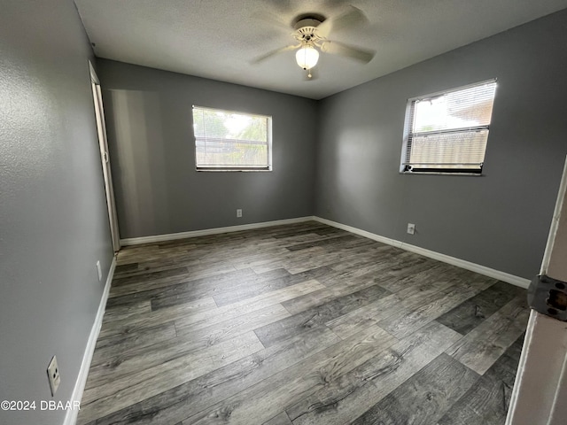 empty room with ceiling fan and dark hardwood / wood-style flooring