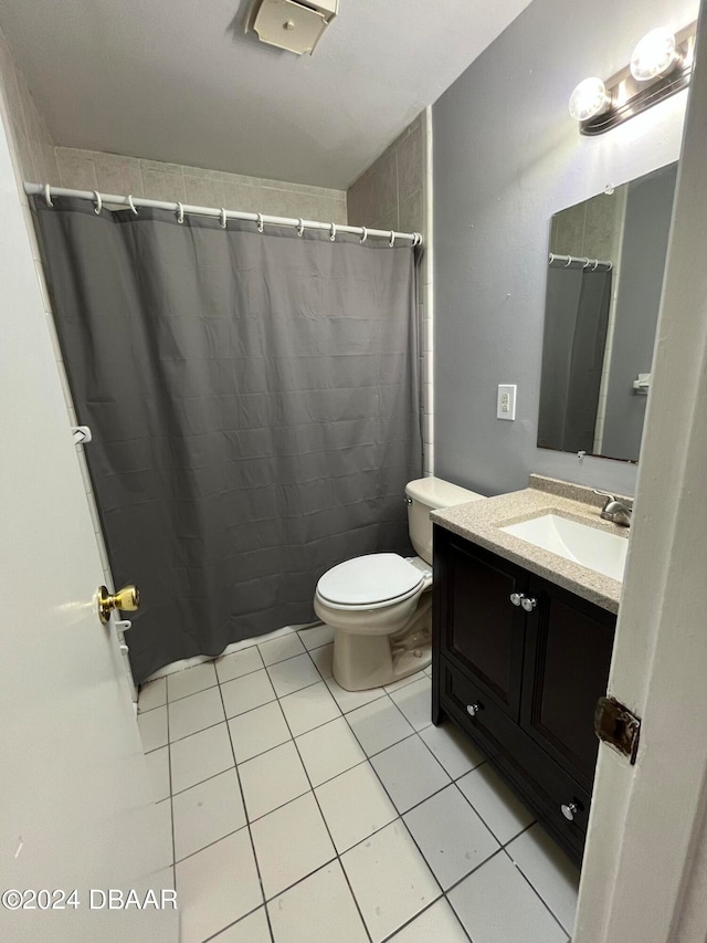 bathroom featuring toilet, a shower with curtain, vanity, and tile patterned floors