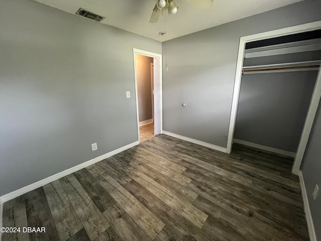 unfurnished bedroom featuring ceiling fan, a closet, and dark hardwood / wood-style flooring