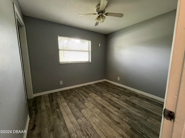 empty room with dark wood-type flooring and ceiling fan