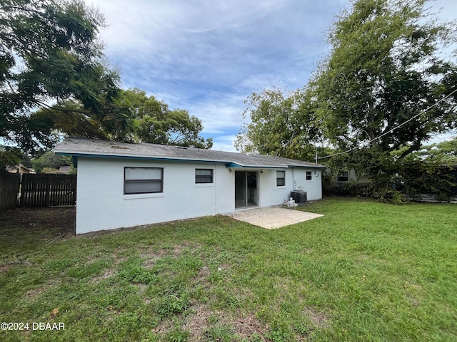 back of property featuring central air condition unit, a patio area, and a yard