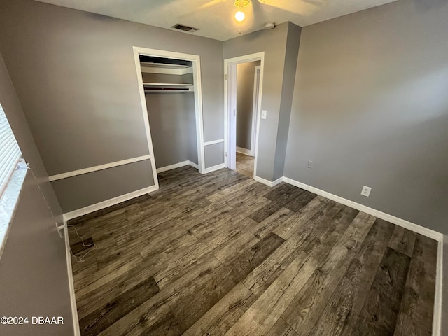 unfurnished bedroom with ceiling fan, dark hardwood / wood-style floors, and a closet