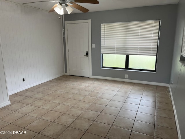 tiled empty room featuring ceiling fan