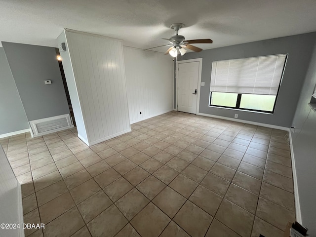 spare room featuring light tile patterned flooring, ceiling fan, and a textured ceiling