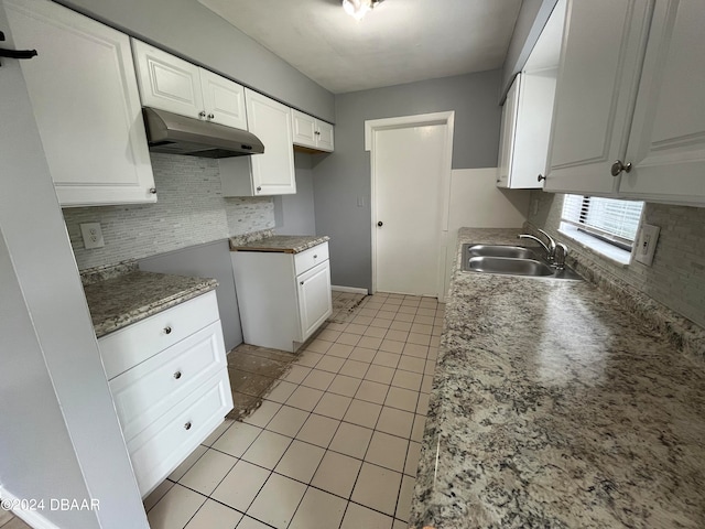 kitchen featuring white cabinets, light tile patterned flooring, sink, and backsplash