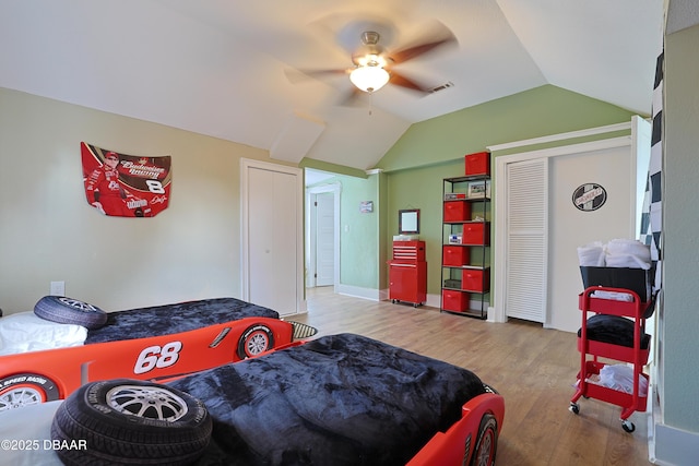 bedroom with ceiling fan, lofted ceiling, and light hardwood / wood-style flooring