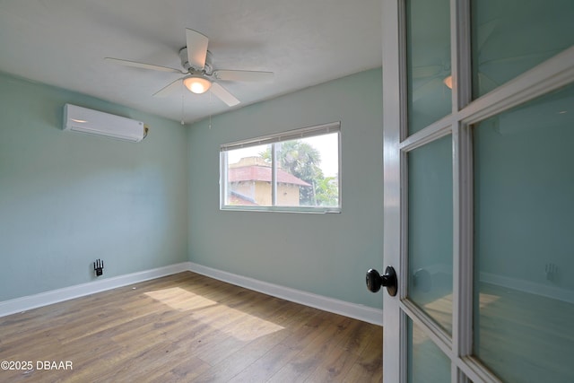 empty room featuring ceiling fan, wood-type flooring, and a wall unit AC