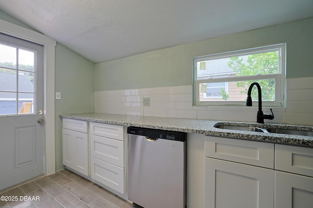 kitchen featuring dishwasher, light stone countertops, sink, and white cabinets