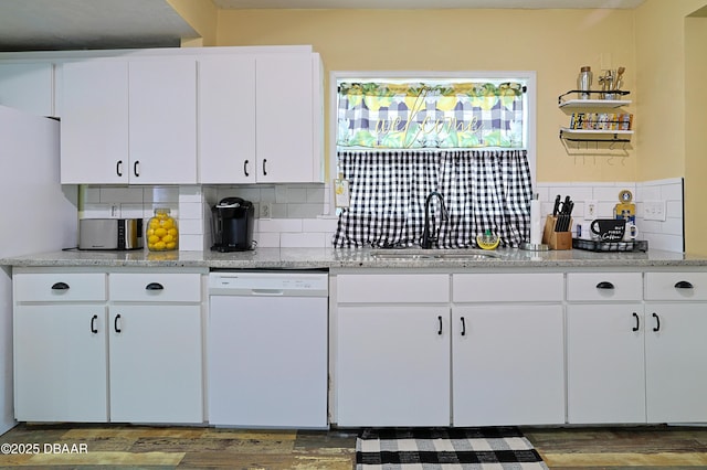 kitchen featuring sink, dishwasher, light stone countertops, decorative backsplash, and white cabinets