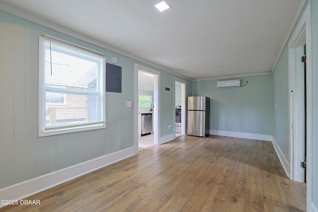 empty room featuring crown molding, hardwood / wood-style floors, and an AC wall unit