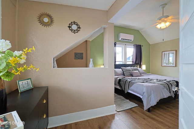 bedroom featuring hardwood / wood-style floors, vaulted ceiling, an AC wall unit, and ceiling fan