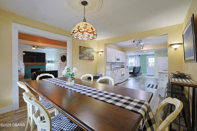 dining space featuring a brick fireplace and dark hardwood / wood-style floors