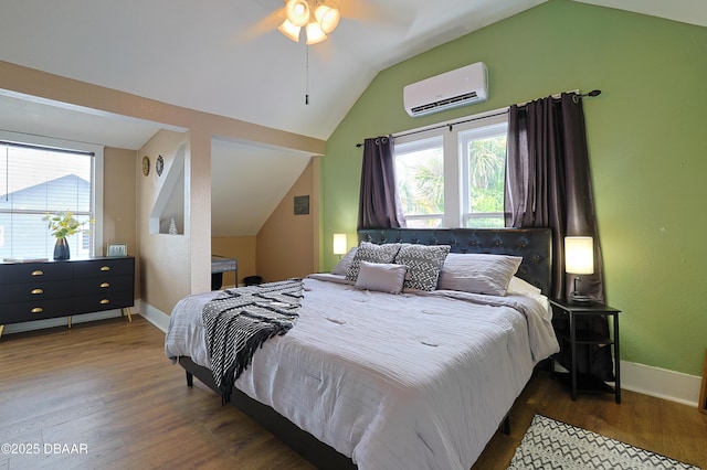 bedroom featuring dark wood-type flooring, ceiling fan, a wall mounted air conditioner, and vaulted ceiling