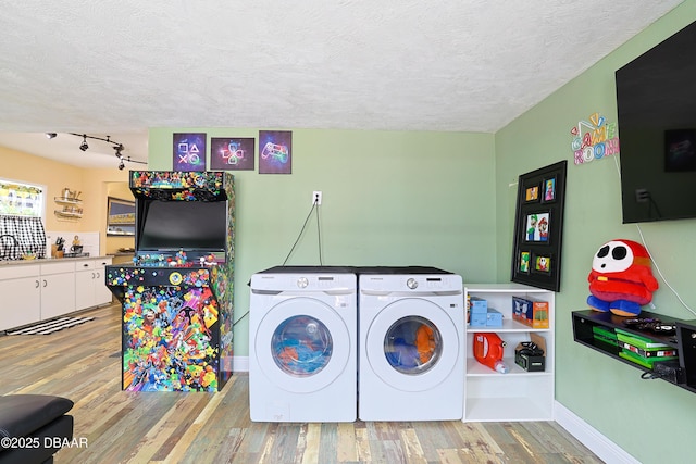 laundry room featuring independent washer and dryer, wood-type flooring, and a textured ceiling