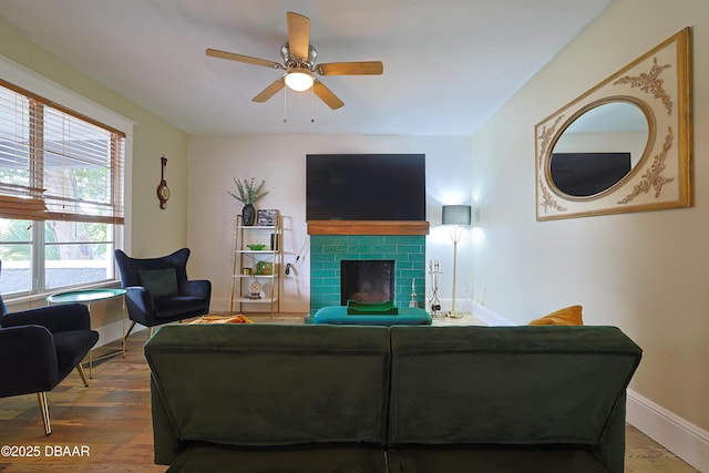 living room featuring hardwood / wood-style flooring, ceiling fan, and a fireplace