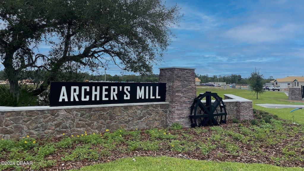 community / neighborhood sign featuring a lawn